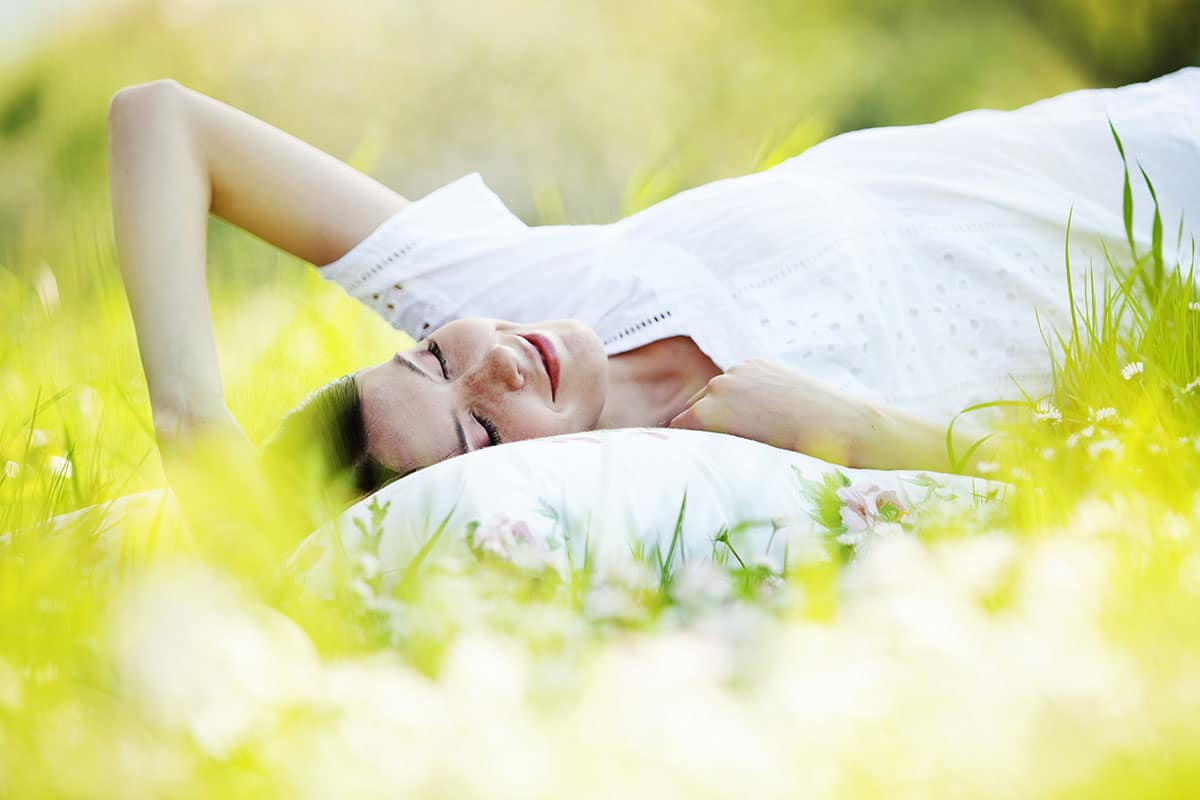 How to Stop Snoring Naturally - Woman sleeping in nature.