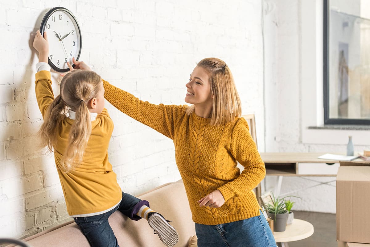 Mother and daughter changing the time for Daylight Savings Time