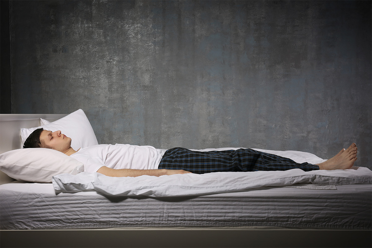 Man in bed experiencing sleep paralysis.